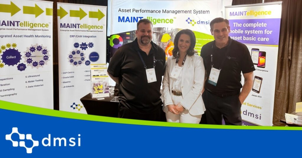Two men and 1 female standing at a conference booth posing for a picture.