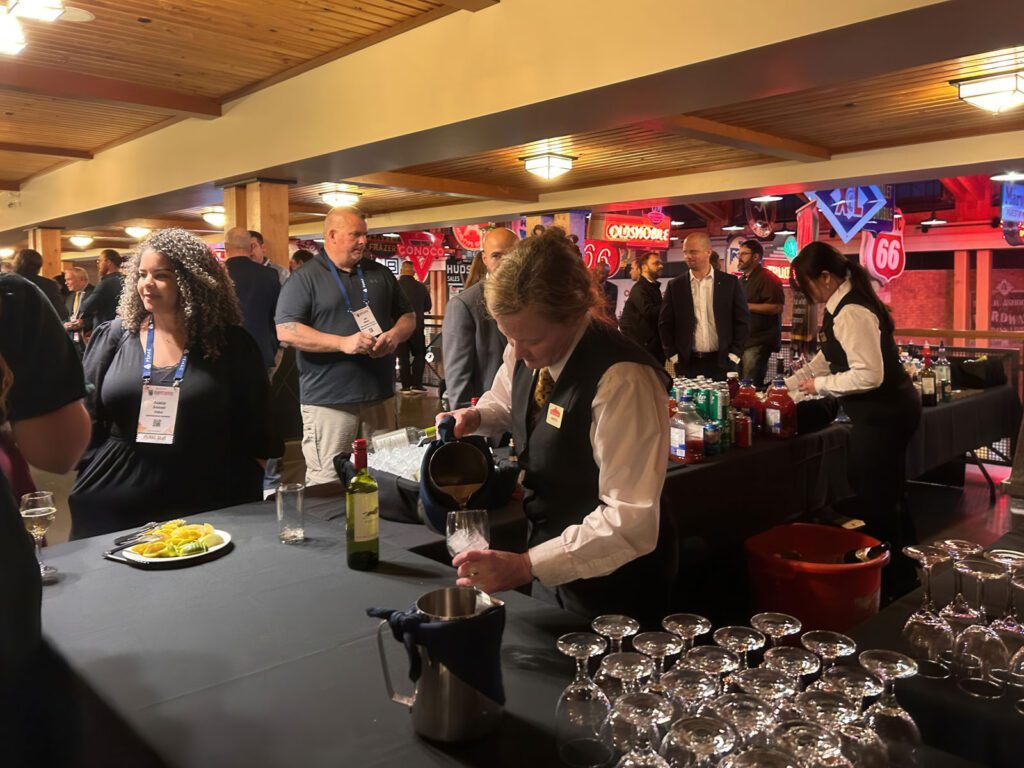 Ballroom food and drink table with people lined up while being served.