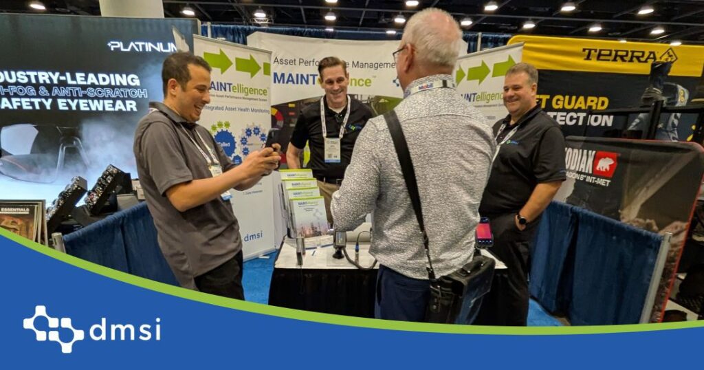 Four men huddled around a conference booth, having a conversation.