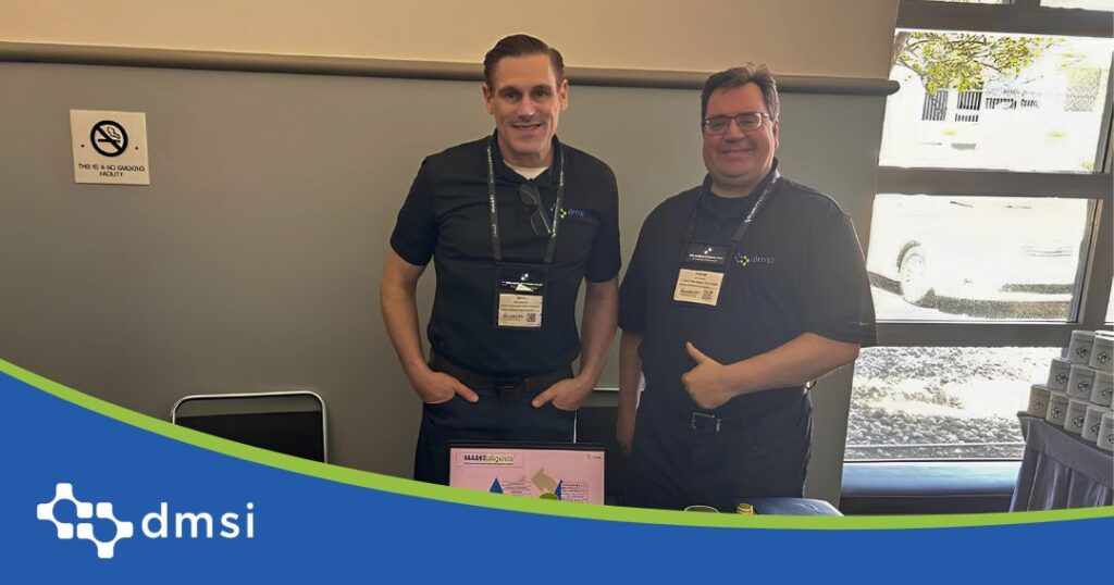 DMSI team members at The Reliability Conference 2026 standing beside MAINTelligence asset management and maintenance reliability software booth.