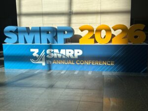 Large blue and yellow SMRP 2026 letters above the 34th Annual Conference sign in the Raleigh Convention Center lobby